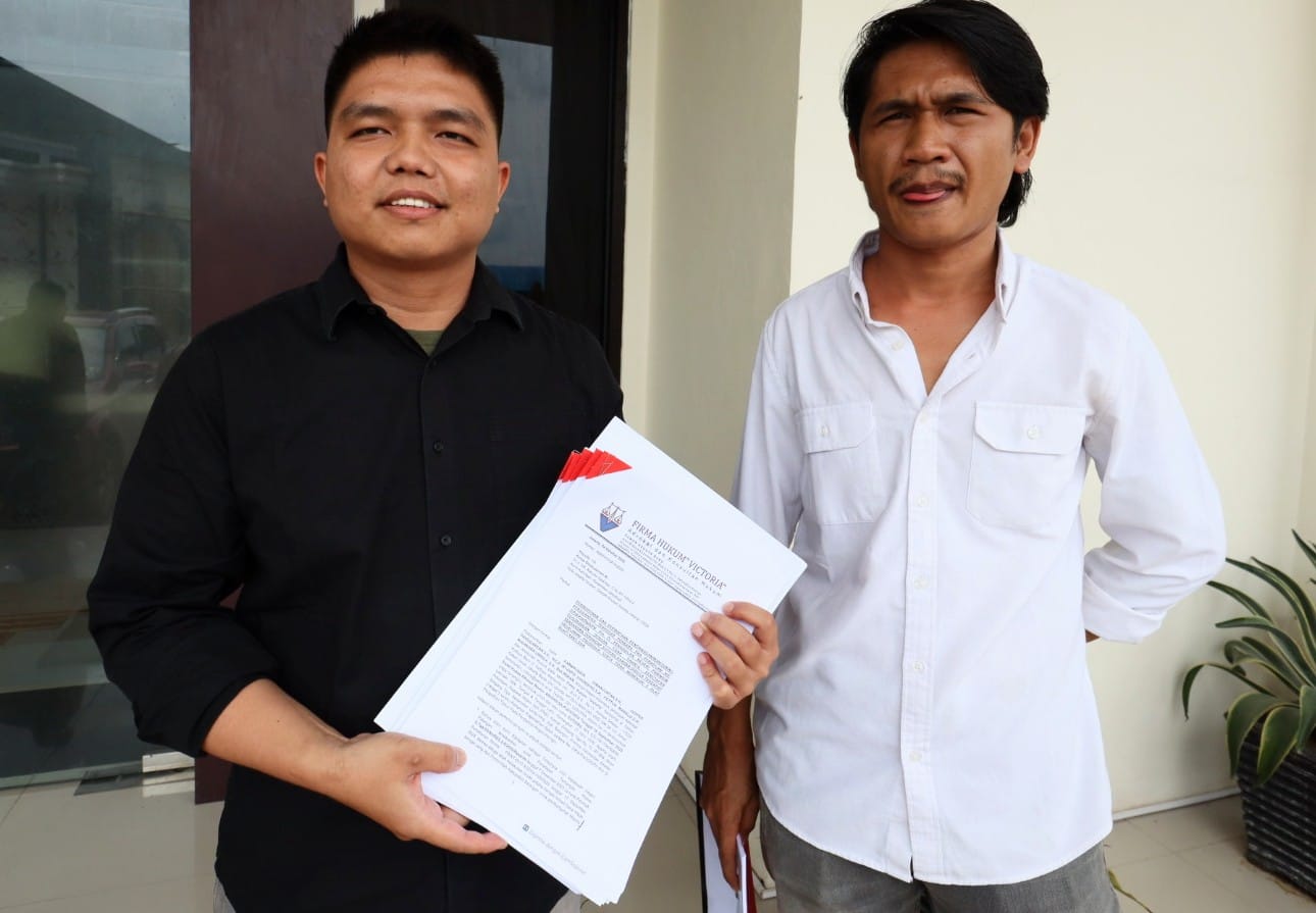 Hottua Manalu (kiri) dan Niko I Sihombing kuasa hukum Eks Sekda Balangan, Kalimantan Selatan, Sutikno menunjukkan laporan atas dugaan kesewenangan kejaksaan atas kliennya di Pengadilan Negeri Paringin, Jumat (10/10/2025). Foto: Apakabar.co.id/Fauzi Fadila